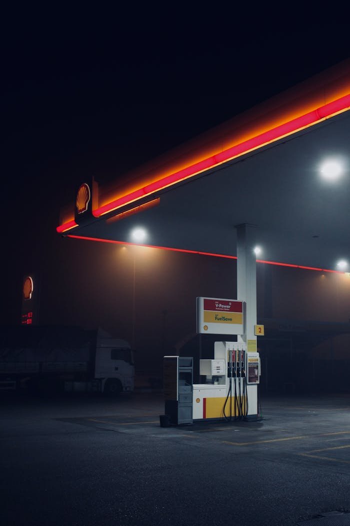 Moody nighttime scene of a gas station in Ankara, Türkiye, highlighting its illuminated structure.